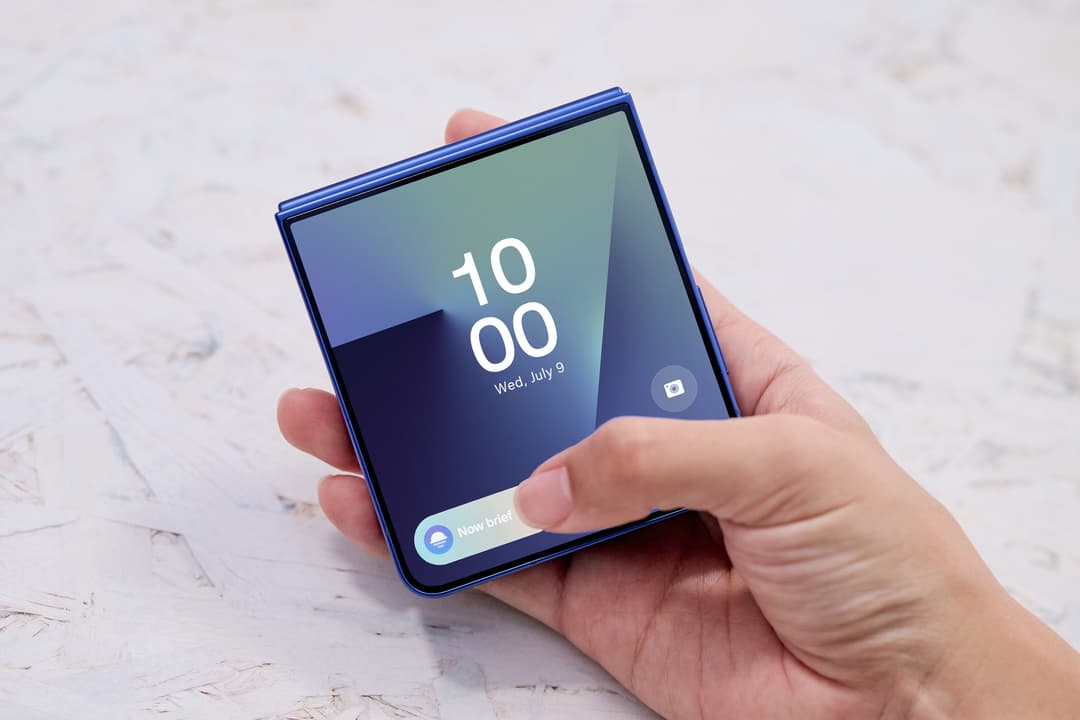 Samsung Galaxy Z Flip7 bleu ouvert en main affichant l'écran de couverture avec l'heure, la date et widgets de notification