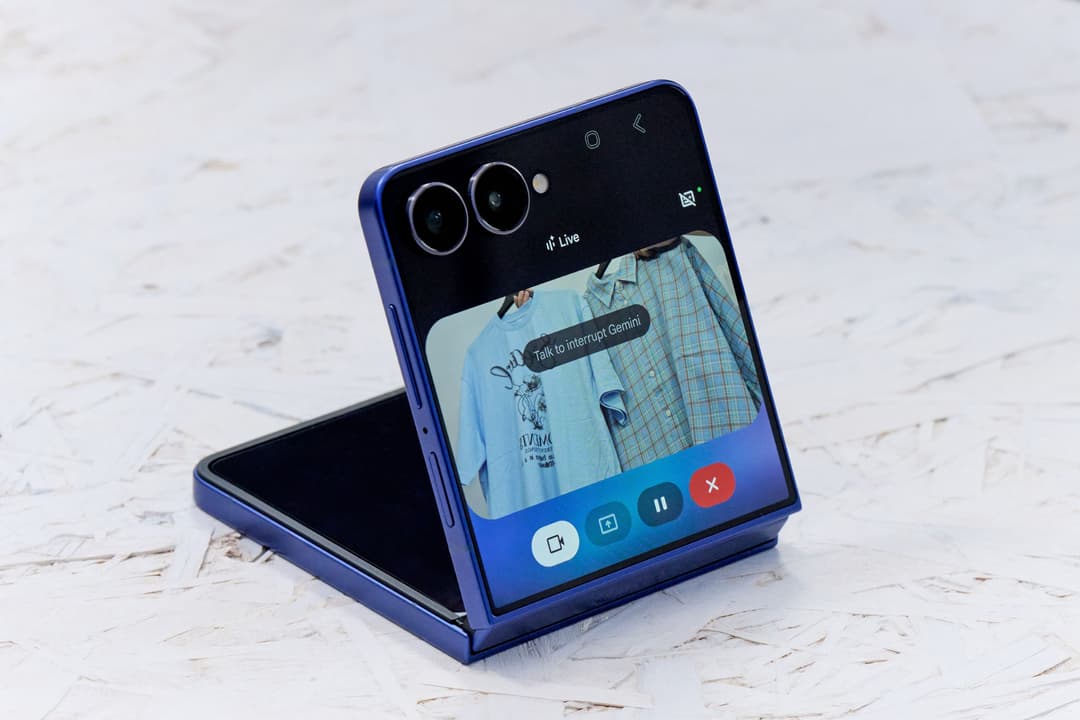 Samsung Galaxy Z Flip7 ouvert en bleu, affichant un écran de vidéo en direct avec widget de commandes et double caméra
