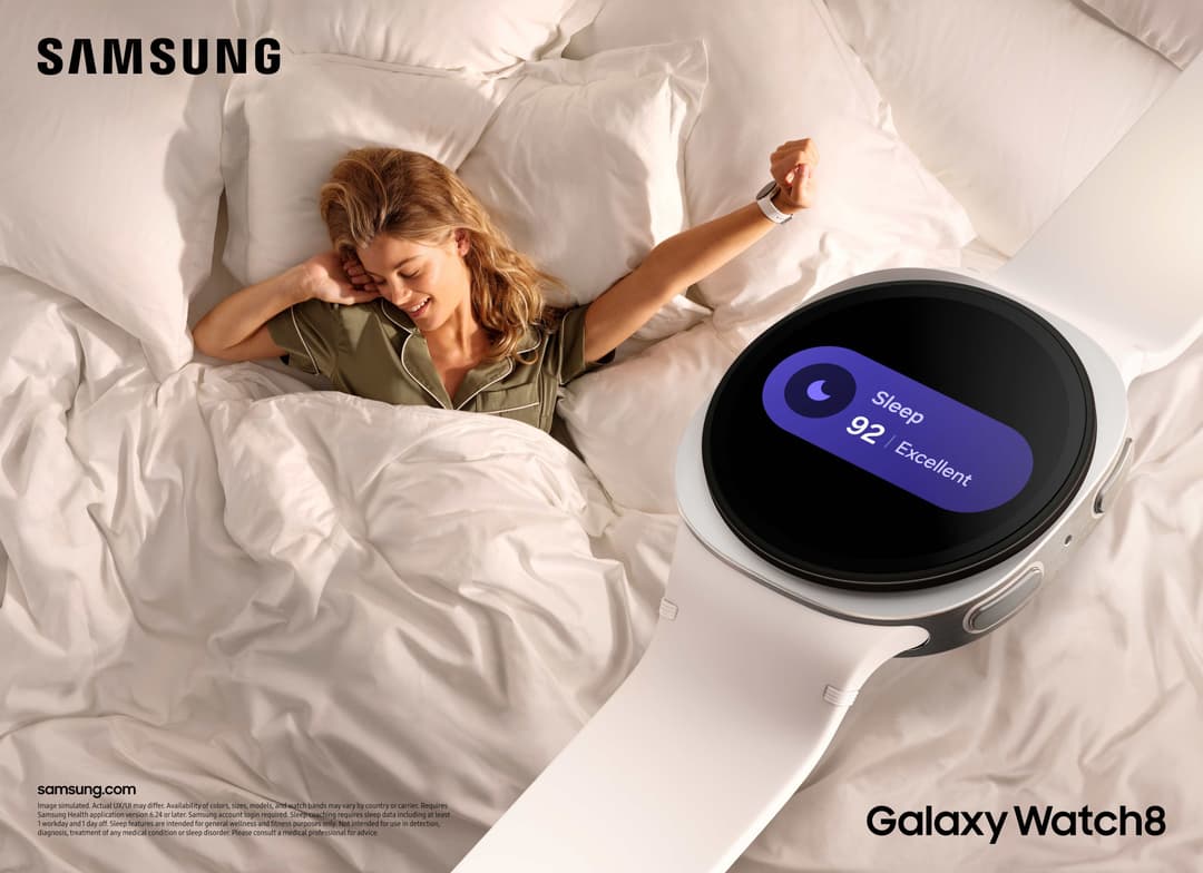 Femme au lit souriante portant une Galaxy Watch8 affichant un score de sommeil de 92 excellent