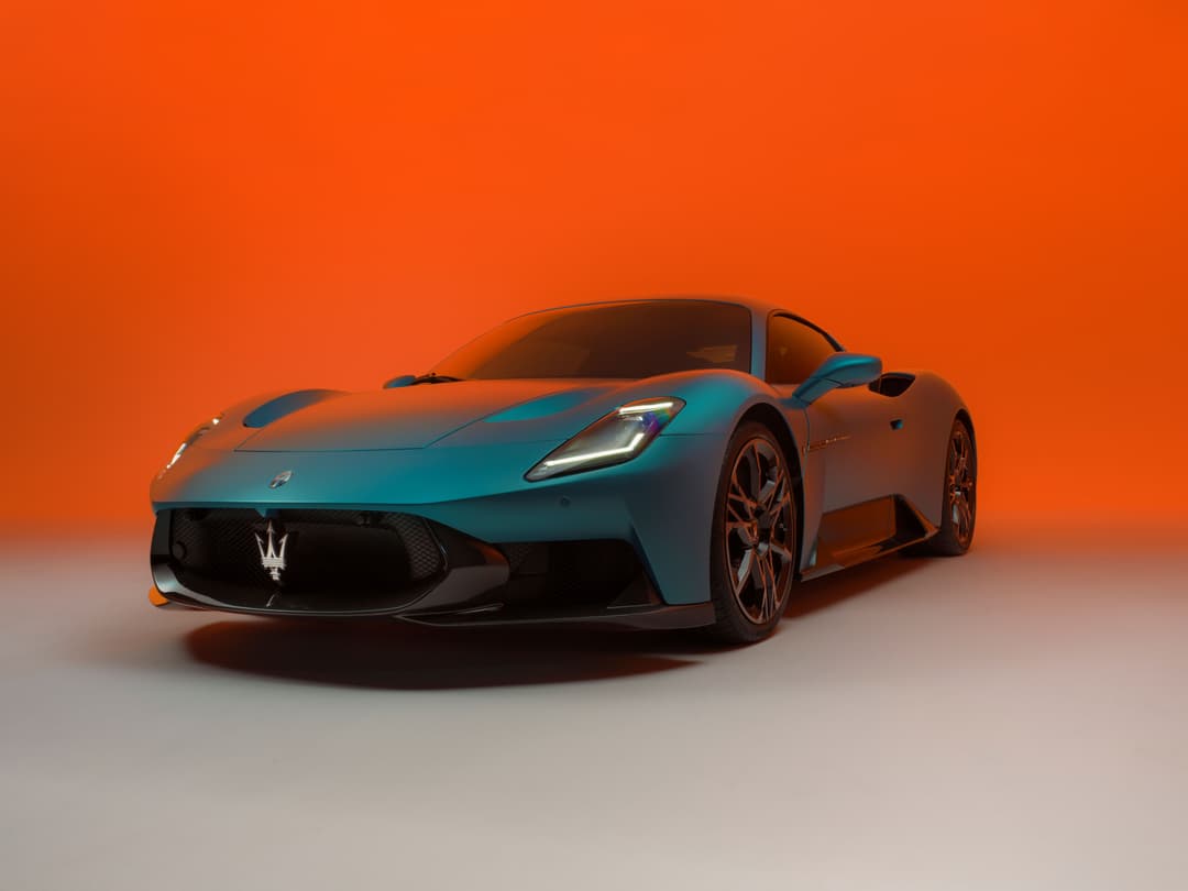 Maserati MC20 MCPURA bleu turquoise de profil trois quarts, fond dégradé orange et gris