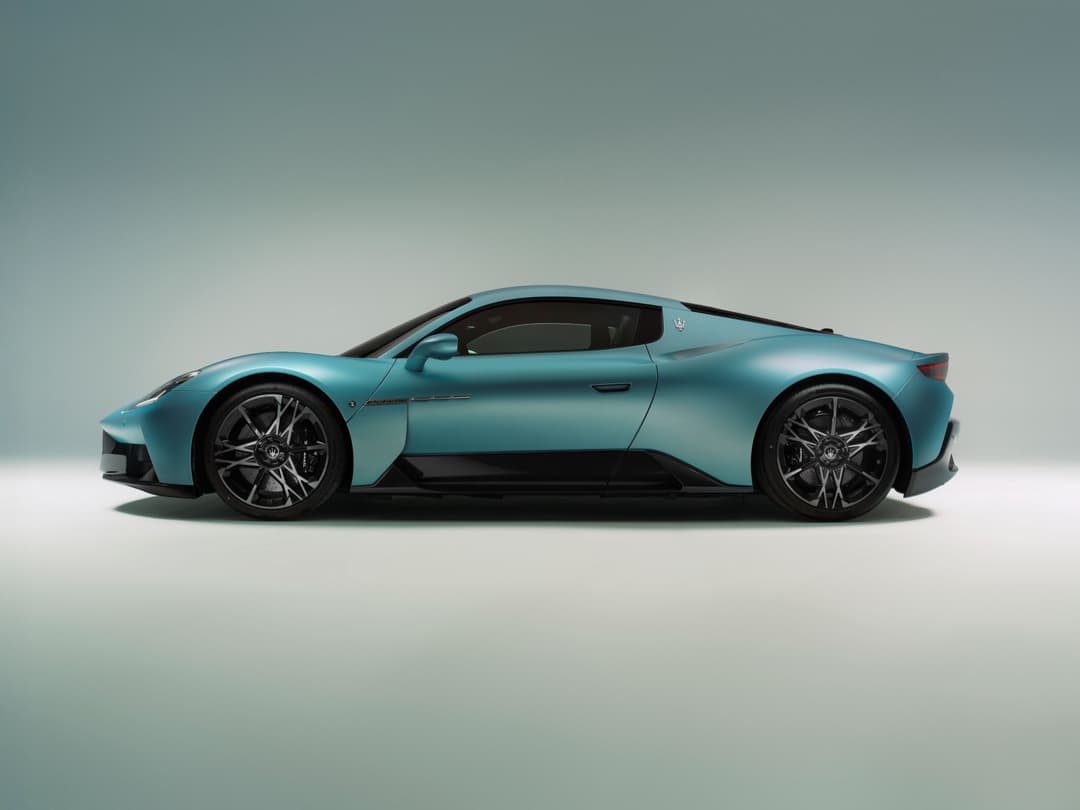 Maserati MCPURA de profil, coupé sport bleu turquoise avec jantes noires, sur fond gris épuré