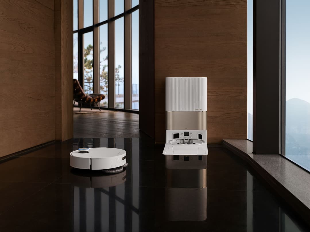 Robot aspirateur et station de nettoyage Dreame blancs dans un intérieur moderne avec vue panoramique sur montagne