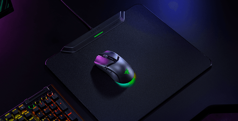 Razer Cobra HyperSpeed, souris gaming noire avec éclairage RGB violet et turquoise, posée sur un tapis de souris noir
