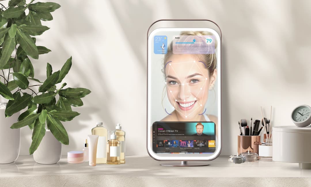 Miroir connecté Samsung affichant le visage d'une femme avec analyse de peau, entouré de produits de beauté et de décoration