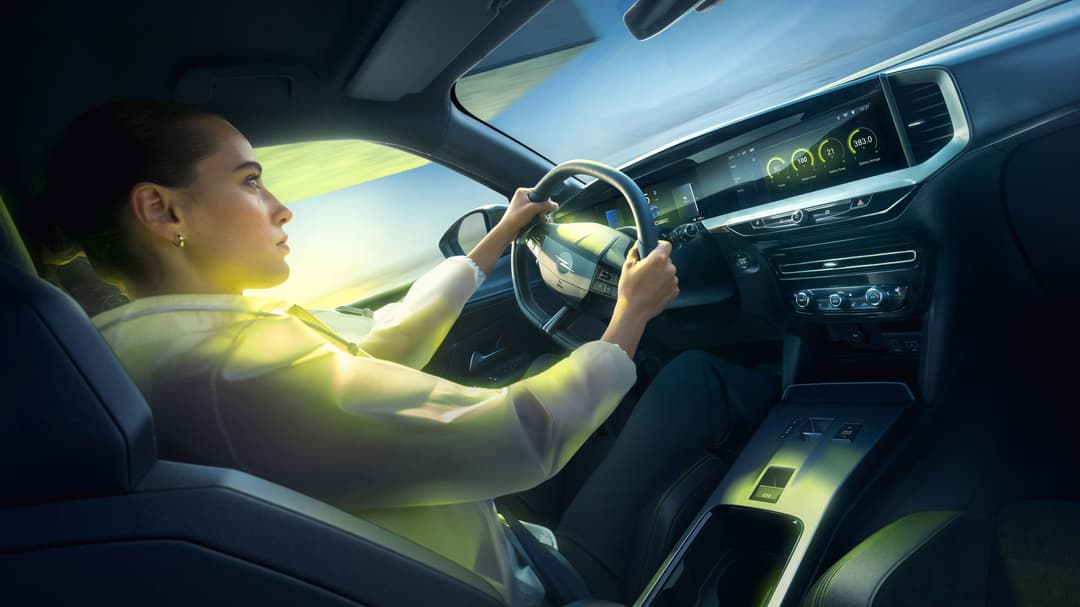 Intérieur de l'Opel Mokka GSE avec une femme au volant, écran tactile et design épuré