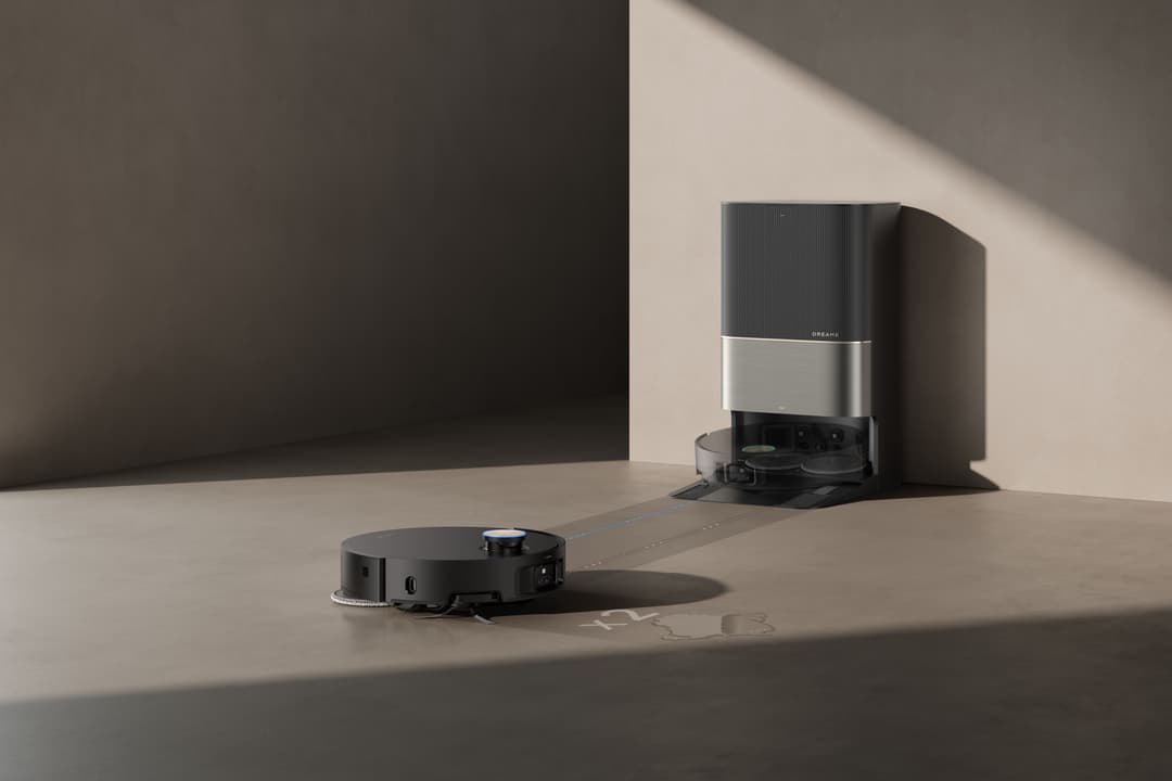 Aspirateur robot Dreame X50 Ultra Complete noir et sa station d'accueil PowerDock grise sur un sol beige