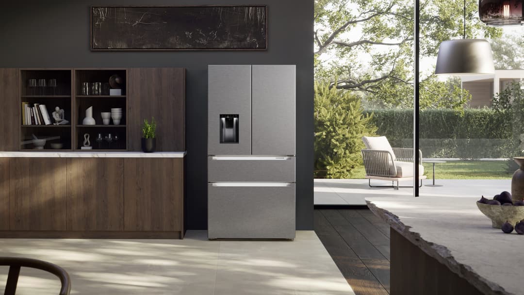 Réfrigérateur Liebherr gris acier dans une cuisine moderne avec meubles en bois, terrasse et jardin en arrière-plan