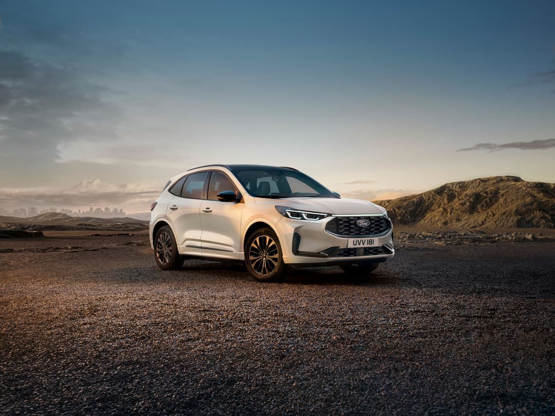Ford Kuga Sound Edition blanc avec jantes dorées, photographié en paysage désertique au coucher de soleil