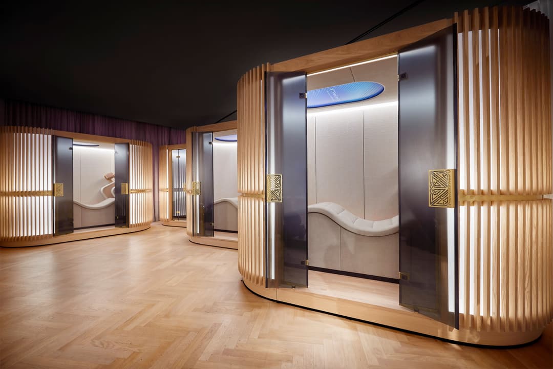 Intérieur du Mind Oasis de Rituals Cosmetics avec cabines de relaxation aux parois de bois et verre, sol en parquet clair
