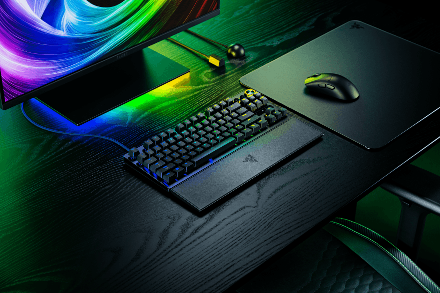 Clavier Razer Huntsman V3 Pro 8KHz noir avec rétroéclairage RGB, accompagné d'une souris gaming et d'un tapis, sur un bureau en bois