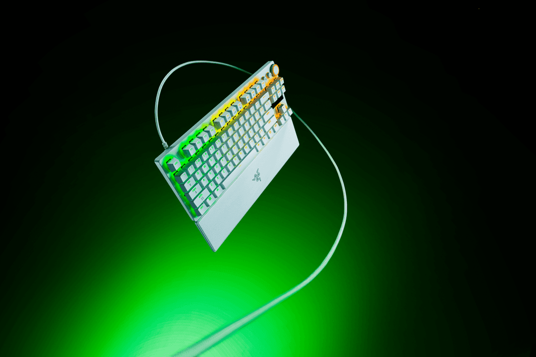 Clavier mécanique Razer Huntsman V3 Pro blanc et noir avec repose-poignet magnétique, sur fond vert dégradé