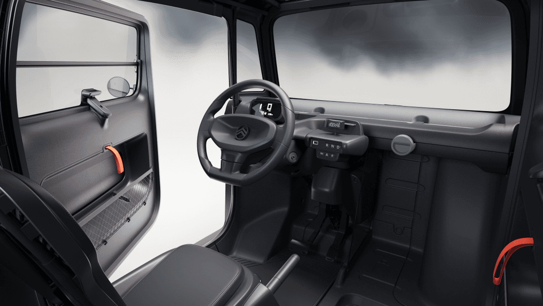 Intérieur de la Citroën Ami Dark Side avec volant noir, sièges gris et accents orange, tableau de bord minimaliste