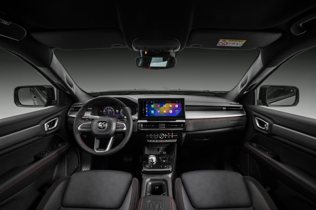 Intérieur du RAM Rampage avec volant de marque RAM, écran tactile central, sièges noirs et accents rouges, tableaux de bord structurés pour le conducteur