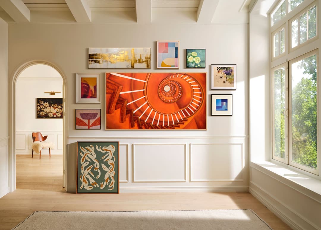 Écran Samsung avec escalier en spirale orange affichant des images artistiques dans un salon lumineux