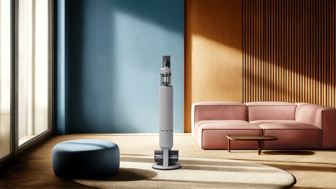 Samsung The Frame Pro, téléviseur design blanc et gris, exposé dans un salon moderne avec canapé rose et pouf bleu