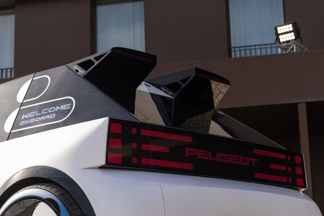 PEUGEOT Polygon Concept, concept-car blanc et noir aux formes géométriques, avec ailerons angulaires et feu arrière pixelisé rouge