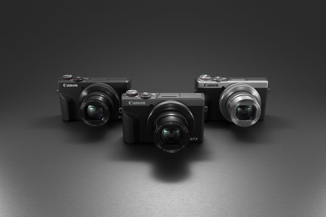 Canon PowerShot G7X édition 30 ans en coloris graphite avec bague sergée, accompagné de deux autres modèles de la série