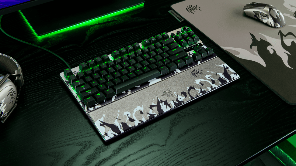 Clavier mécanique Razer NiKo avec touches vertes rétroéclairées et repose-poignets personnalisé, posé sur un bureau gaming noir avec tapis de souris vert fluo