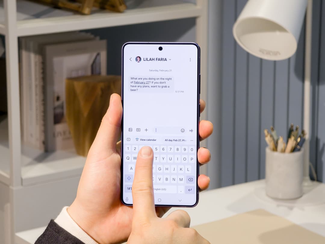Samsung Galaxy S26 à l'écran affichant une conversation avec suggestions de rendez-vous calendrier intégrées