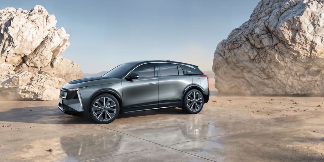 DS N°7, SUV électrique gris argent, stationné entre deux formations rocheuses désertiques, grandes surfaces vitrées visibles