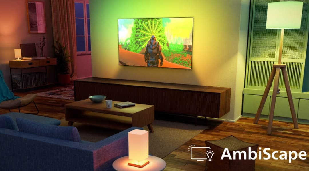 Salon avec téléviseur Philips affichant une scène de jeu vidéo, entouré d'ampoules connectées colorées synchronisées au contenu de l'écran via la technologie AmbiScape