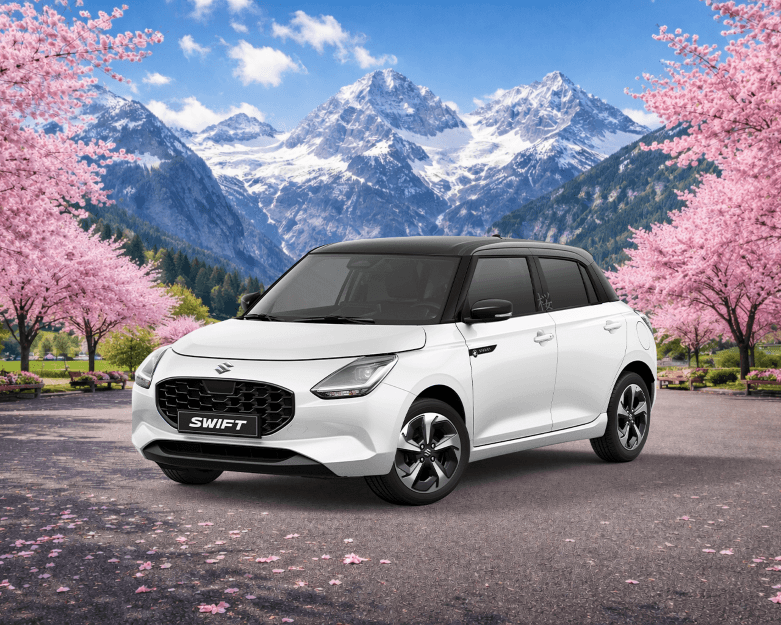 Suzuki Swift blanc édition SAKURA dans un paysage de fleurs de cerisier rose avec montagnes enneigées en arrière-plan