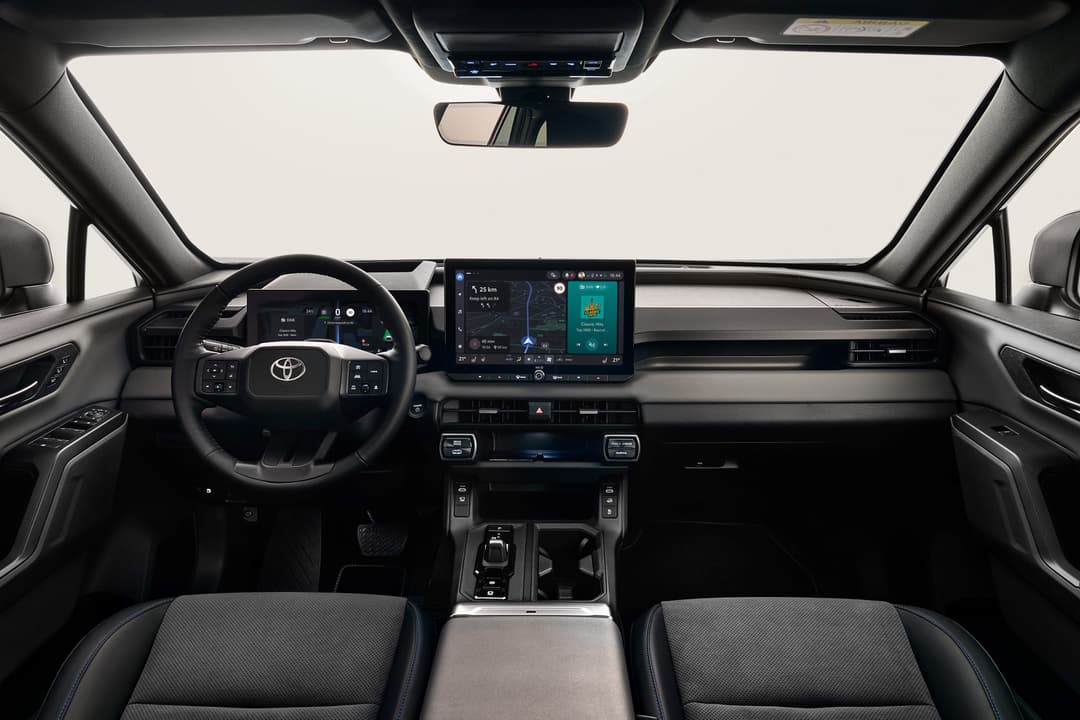 Intérieur du Toyota RAV4 sixième génération avec tableau de bord redessiné, volant et écran tactile numérique, sièges gris et console centrale épurée
