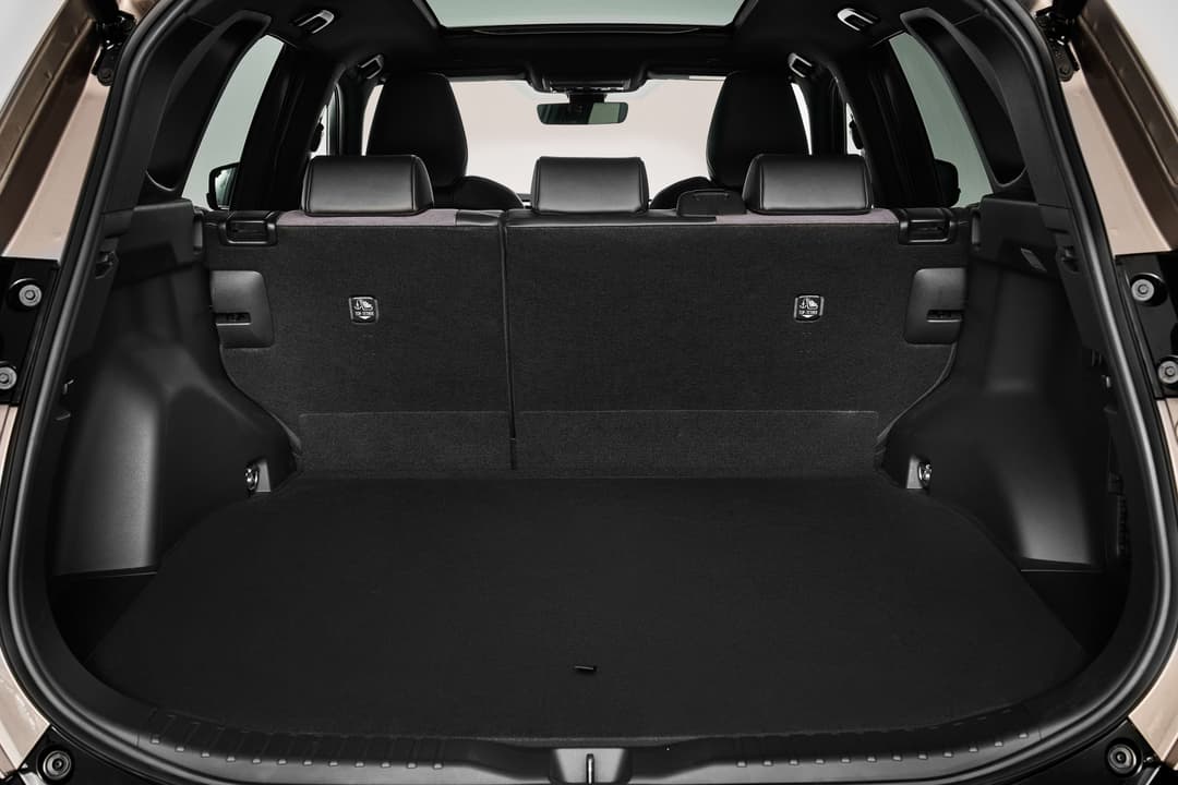 Coffre spacieux du Toyota RAV4 sixième génération avec sièges arrière relevés et portes ouvertes