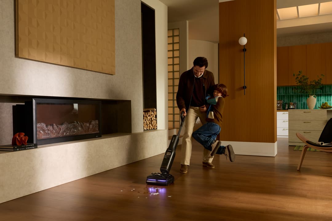 Père et enfant utilisant un aspirateur balai sans fil Roborock série H60 dans un salon moderne avec parquet