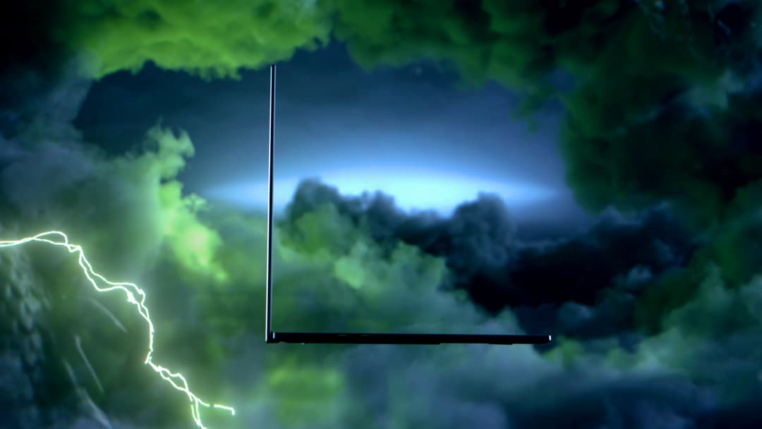 Contour fin d'un ordinateur portable Razer sur fond de ciel orageux avec éclairs verts et bleus