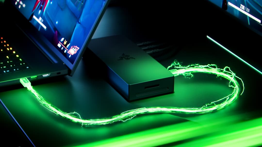 Razer Blade 16 posé sur un tapis de souris vert fluo avec logo Razer luminescent, écran affichant interface gaming