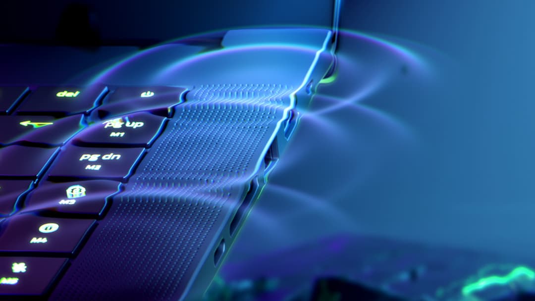 Clavier rétroéclairé d'un ordinateur portable Razer avec touches lumineuses et ports de connectivité visibles sur le côté, fond bleu et violet