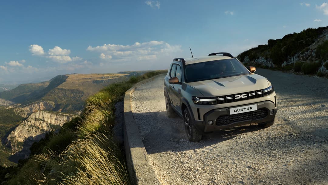 Dacia Duster blanc 4x4 hybrid stationné sur un chemin de montagne avec falaises calcaires en arrière-plan