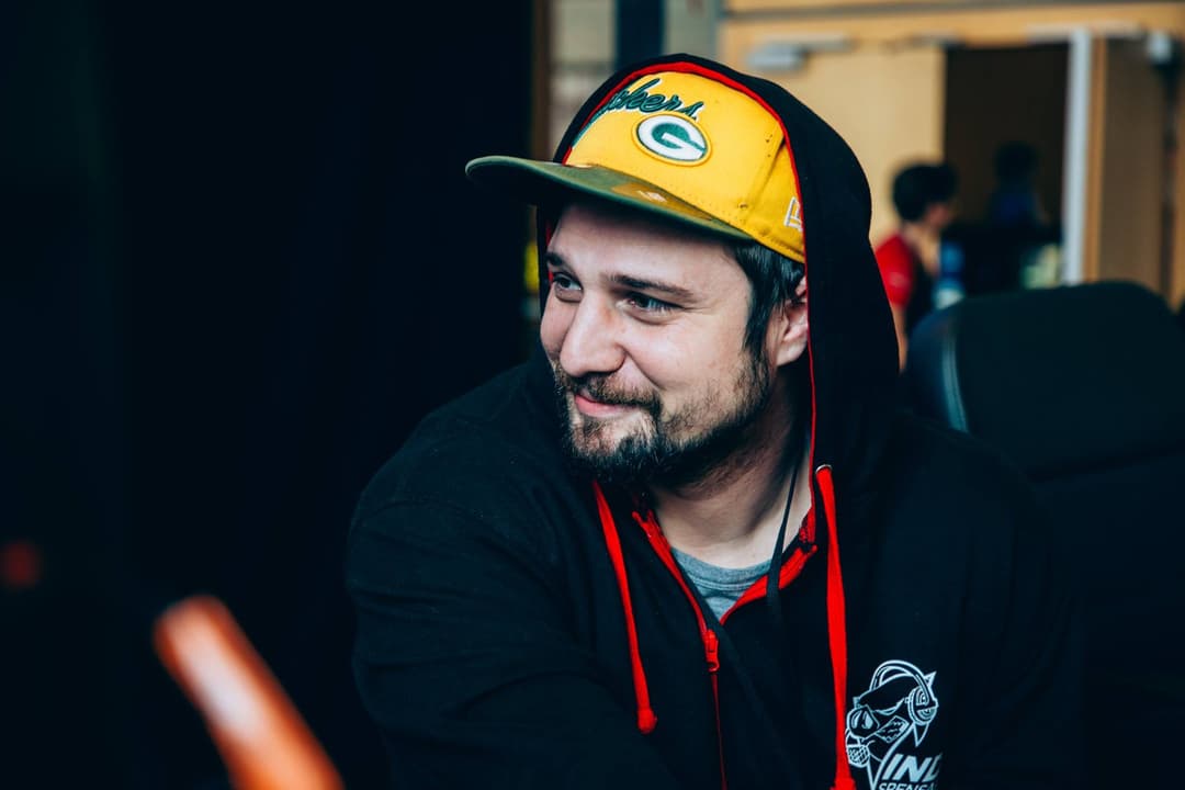 Gius portant une casquette jaune et noire et un sweat à capuche noir lors d'un événement gaming