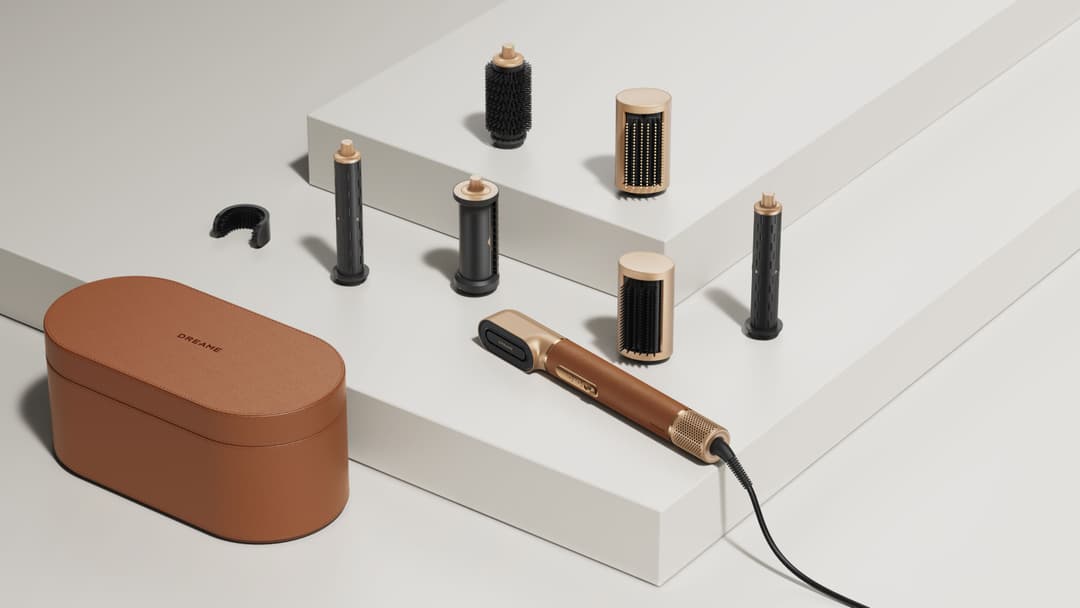 Dreame AirStyle Pro avec ses sept accessoires de coiffage interchangeables en noir et doré, rangés dans leur coffret caramel