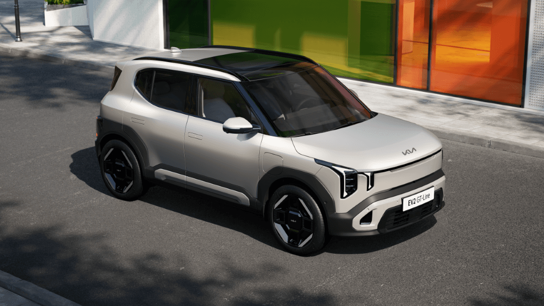 Kia EV2 blanc et noir garé devant une façade colorée, vue trois-quarts