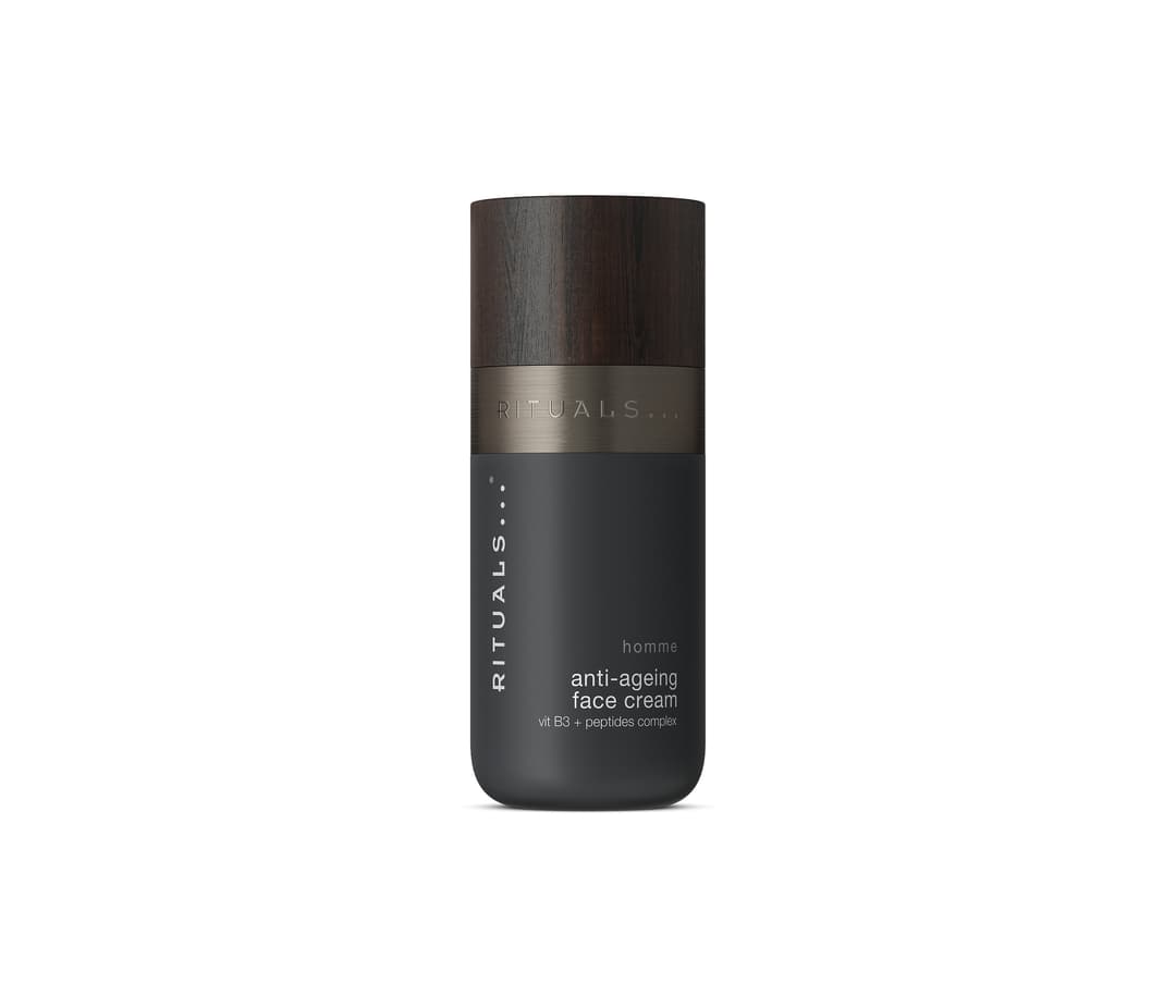 Flacon noir de crème anti-âge Rituals pour homme, avec bande dorée et chapeau en bois sombre