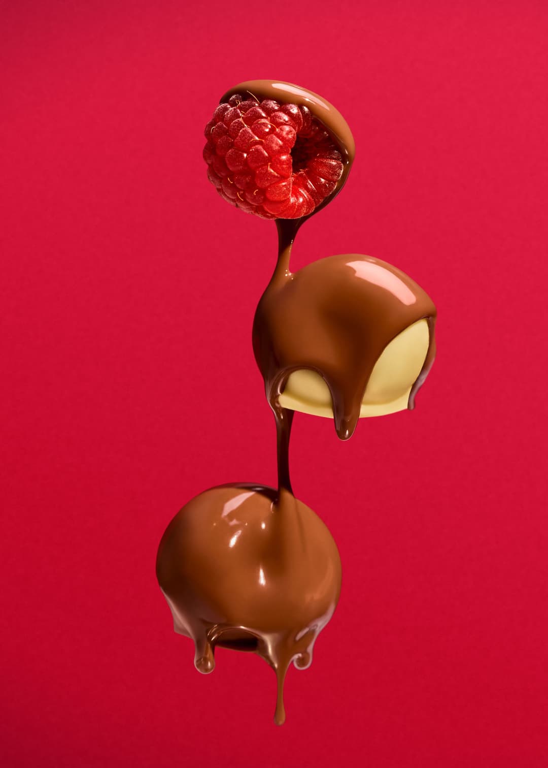 Bonbons au chocolat et framboise empilés, enrobés de chocolat noir et coulis qui coule, sur fond rose