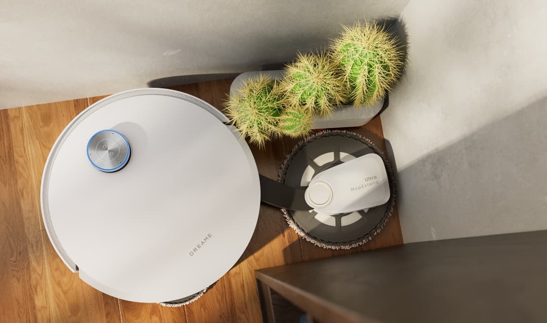 Robot aspirateur blanc Dreame avec station de lavage thermique, vue de dessus sur parquet
