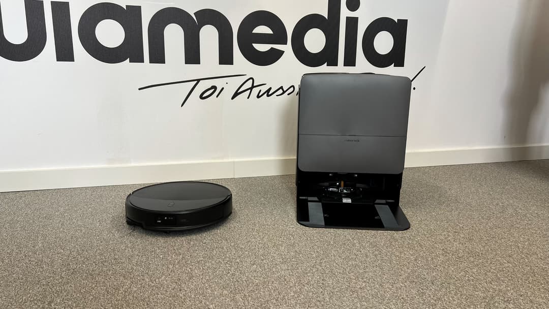 Robot aspirateur Roborock Saros 20 noir et sa station de vidage grise, posés sur un sol gris clair