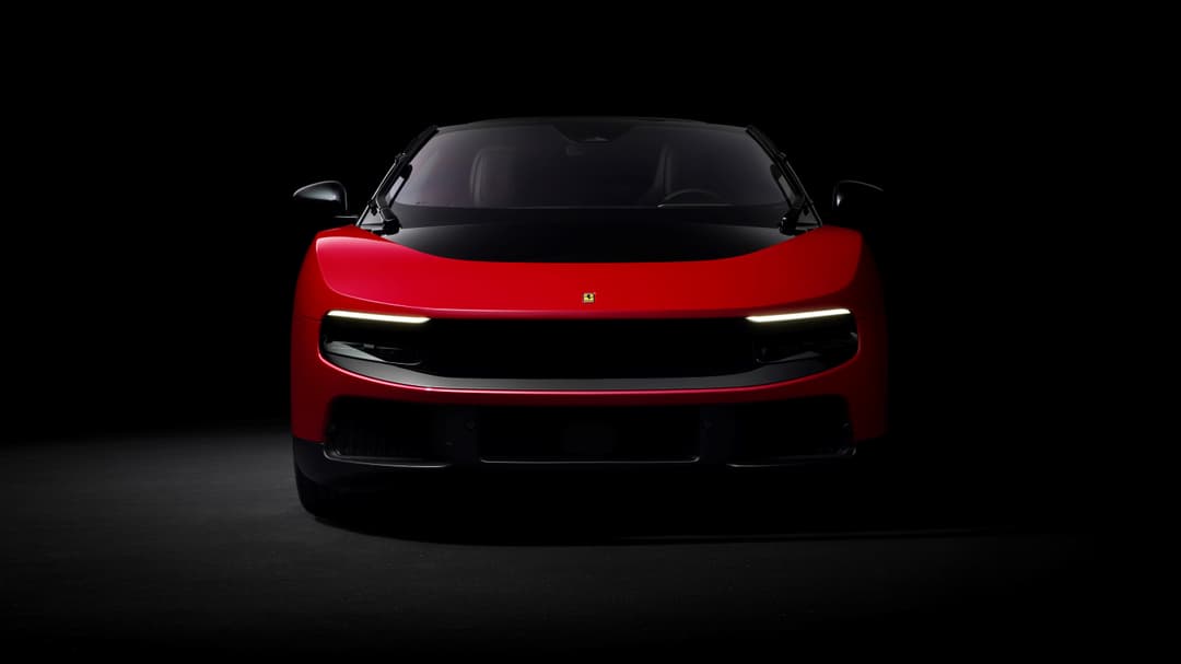 Ferrari Luce rouge vue de face, phares allumés, sur fond noir