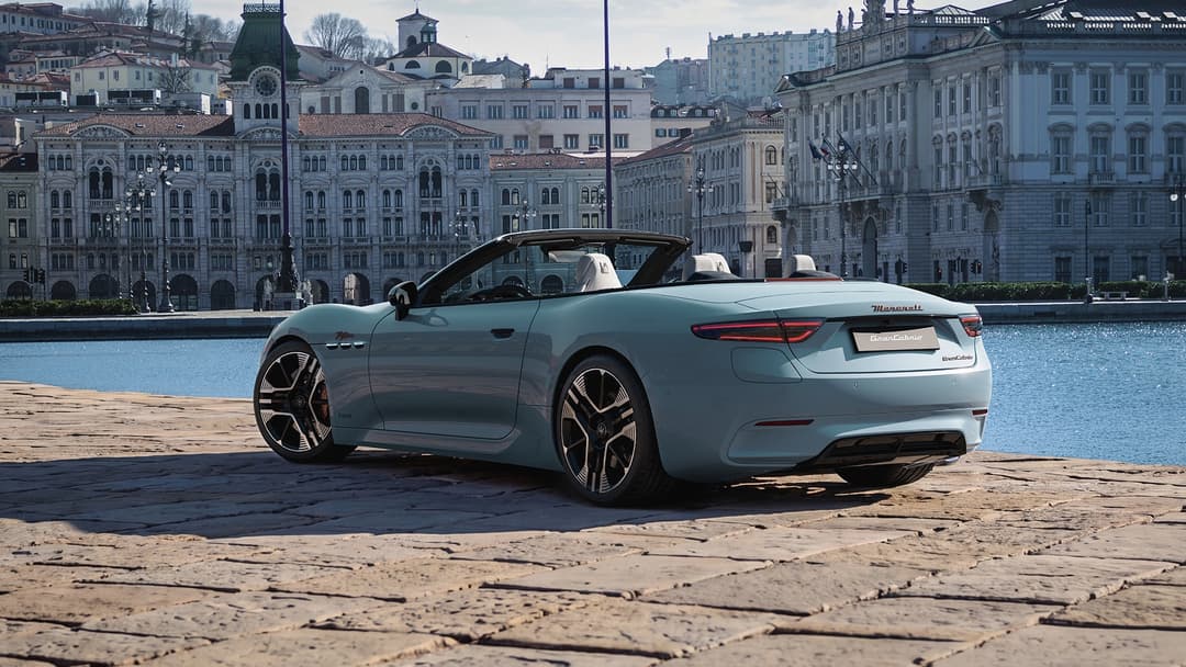 Maserati GranCabrio décapotable bleu clair stationnée au bord d'un canal avec bâtiments historiques en arrière-plan