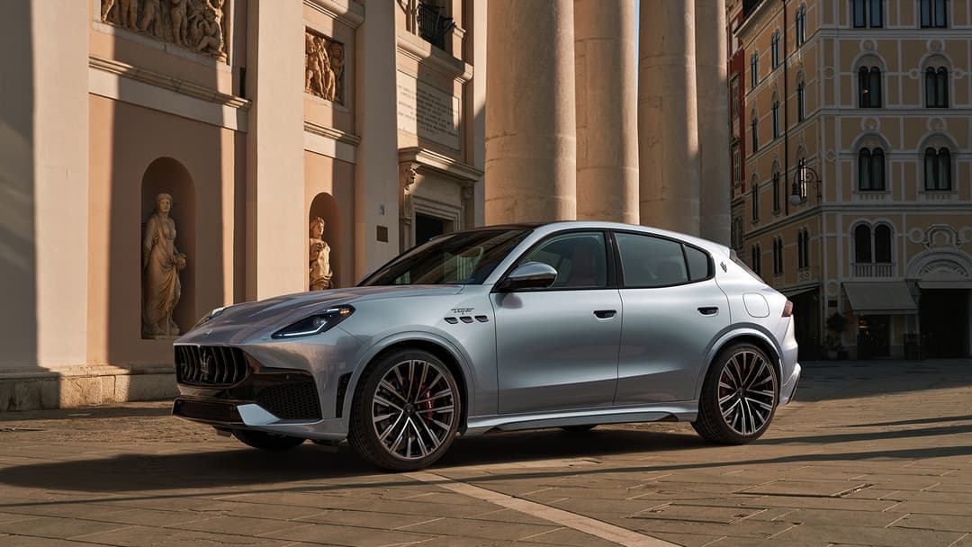 Maserati Grecale gris clair stationnée sur une place pavée devant des bâtiments historiques avec colonnes