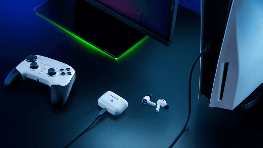 Razer Hammerhead V3 X HyperSpeed blancs avec boîtier de charge et récepteur, entourés d'une manette Xbox et d'appareils gaming