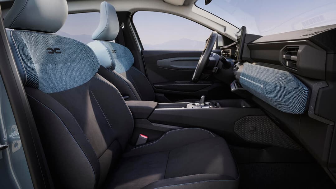 Intérieur du Dacia Striker avec sièges bleus et noirs, volant, tableau de bord et vitrage avant épais