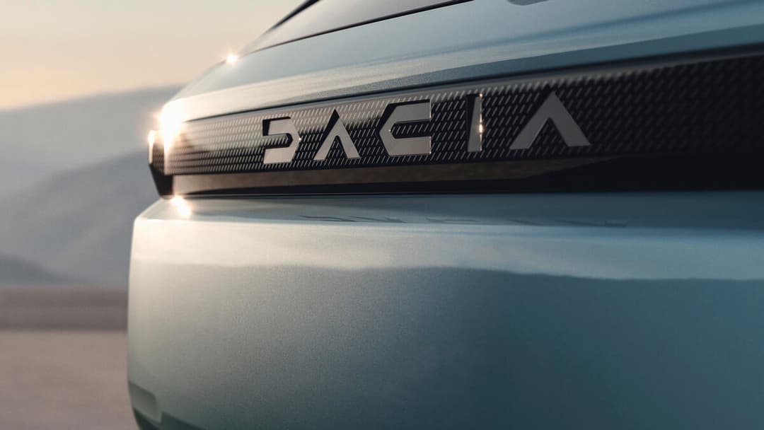 Dacia Striker blanc, détail du logo et de la calandre avant en relief, éclairage naturel