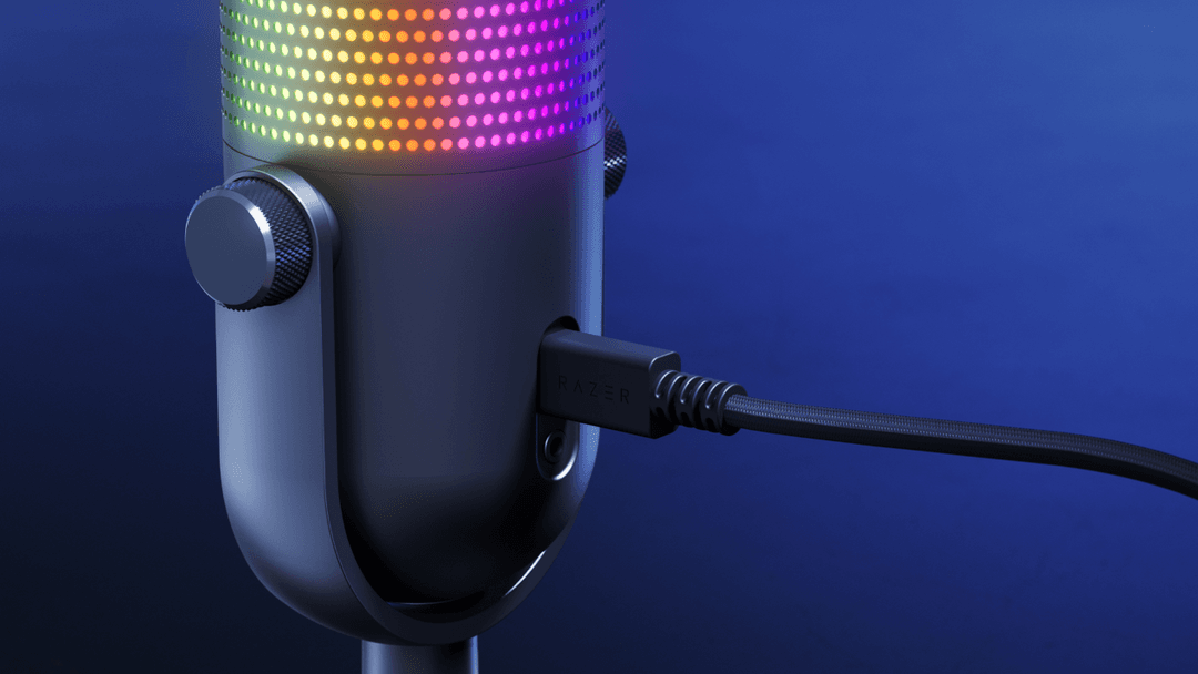 Microphone Razer Seiren V3 Chroma avec anneau RGB illuminé en dégradé vert, orange et rose sur fond bleu
