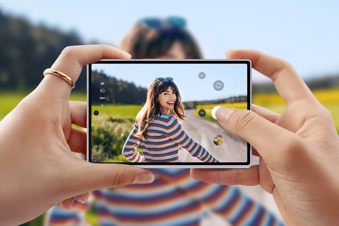 Galaxy Z Fold8 en mode appareil photo affichant une femme en pull rayé devant un paysage verdoyant