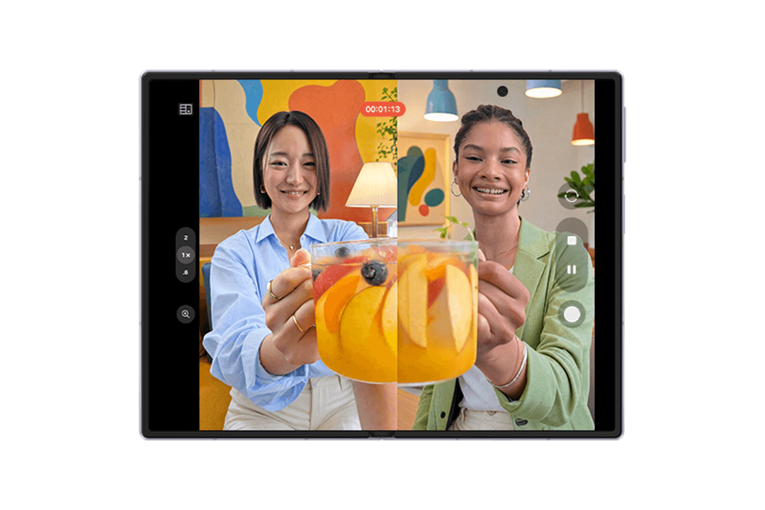 Samsung Galaxy Z Fold8 affichant deux jeunes femmes souriantes tenant un verre de jus d'orange, avec interface de caméra et barre d'outils latérale