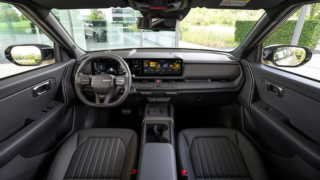 Intérieur du Kia Seltos avec tableau de bord moderne, écran tactile, volant et sièges noirs